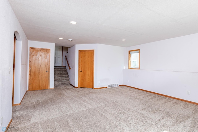 spare room featuring a textured ceiling and carpet flooring