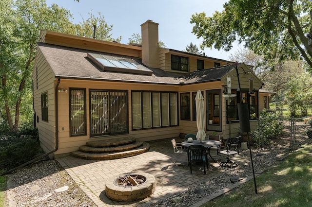 rear view of property featuring a patio area and an outdoor fire pit