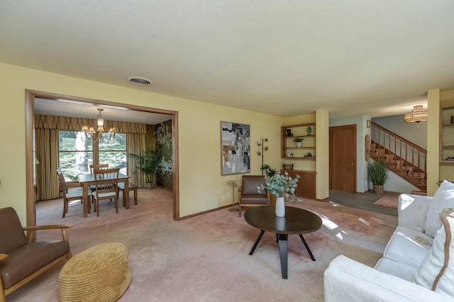 carpeted living room featuring a chandelier