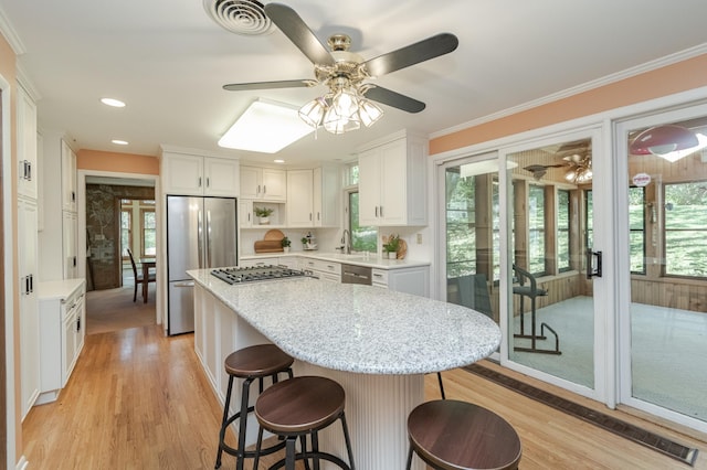 kitchen featuring light wood-type flooring, ceiling fan, stainless steel appliances, and white cabinets