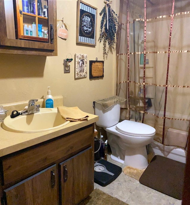 bathroom featuring curtained shower, vanity, and toilet