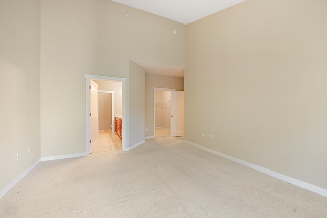 carpeted empty room with a high ceiling