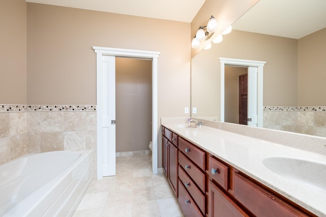 bathroom featuring tile walls, tile patterned flooring, toilet, vanity, and a bathing tub