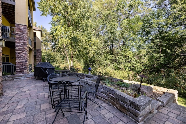 view of patio featuring a balcony and a grill