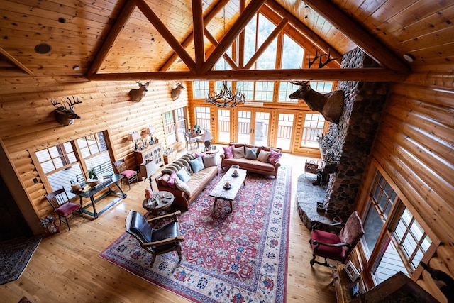 living room featuring light wood-type flooring, a chandelier, high vaulted ceiling, and plenty of natural light