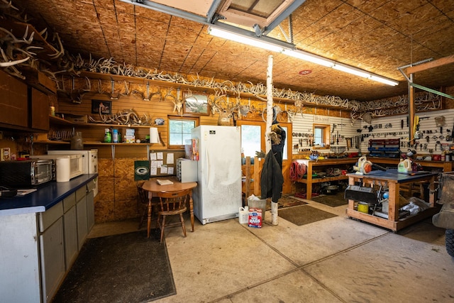 interior space featuring white refrigerator and a workshop area