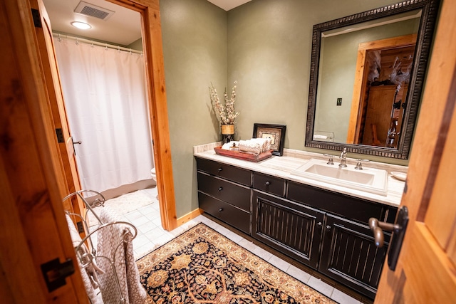 bathroom featuring tile patterned flooring, vanity, and toilet