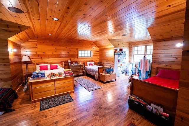 bedroom with multiple windows, vaulted ceiling, and hardwood / wood-style floors