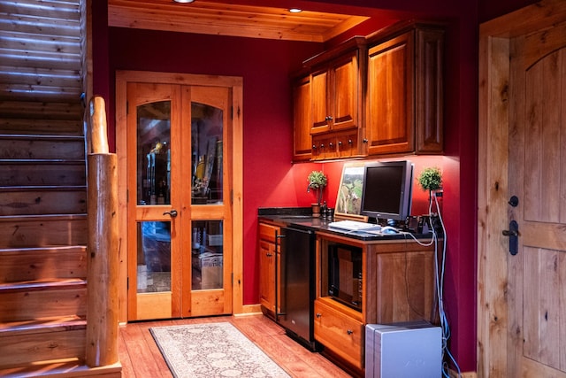 kitchen with light hardwood / wood-style floors and black refrigerator