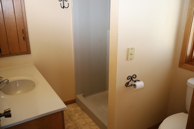 bathroom with vanity, tile patterned floors, toilet, and walk in shower