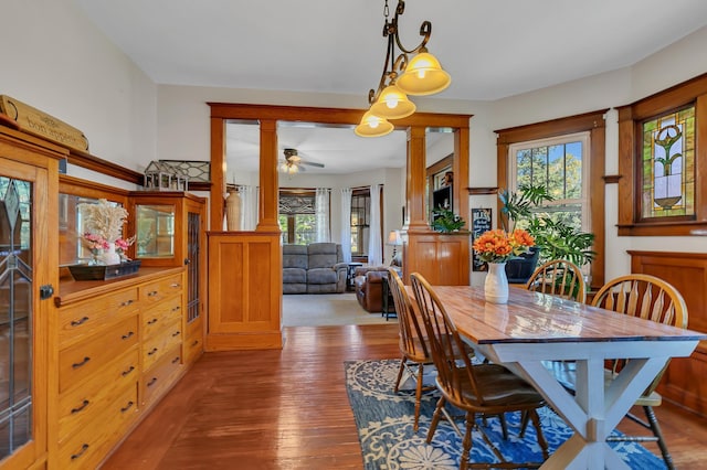 dining space with decorative columns, hardwood / wood-style flooring, and ceiling fan