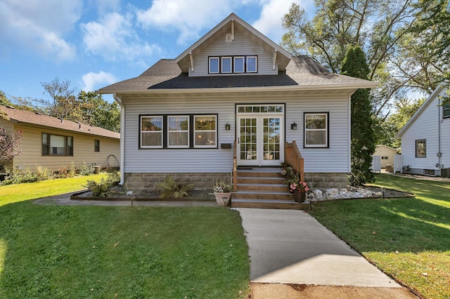 bungalow-style house featuring french doors and a front lawn