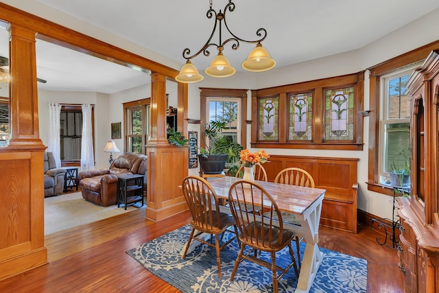 dining room with wood-type flooring and decorative columns