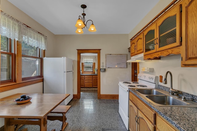 kitchen featuring white appliances, sink, hanging light fixtures, and a notable chandelier