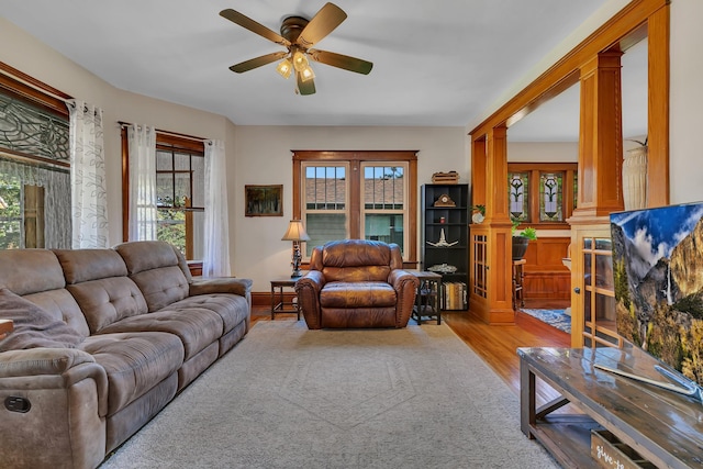 living room with ornate columns, wood-type flooring, plenty of natural light, and ceiling fan