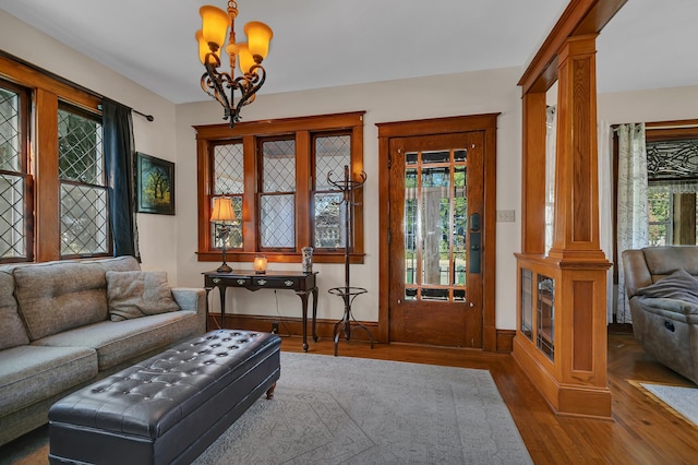 living room with hardwood / wood-style flooring, a chandelier, and decorative columns