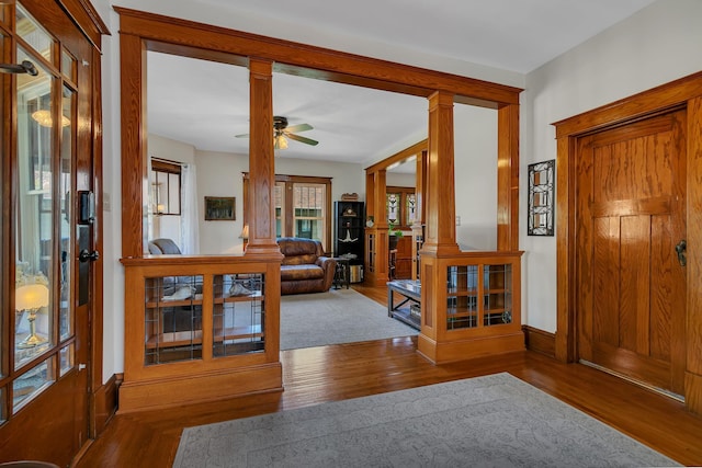 interior space featuring hardwood / wood-style flooring, ceiling fan, and decorative columns