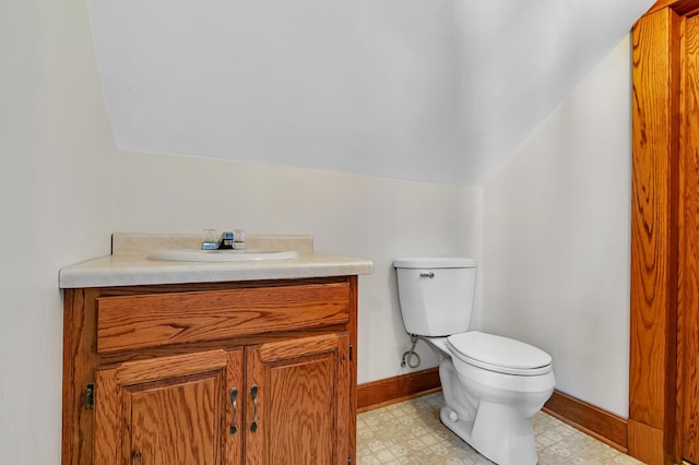 bathroom with vanity, vaulted ceiling, and toilet