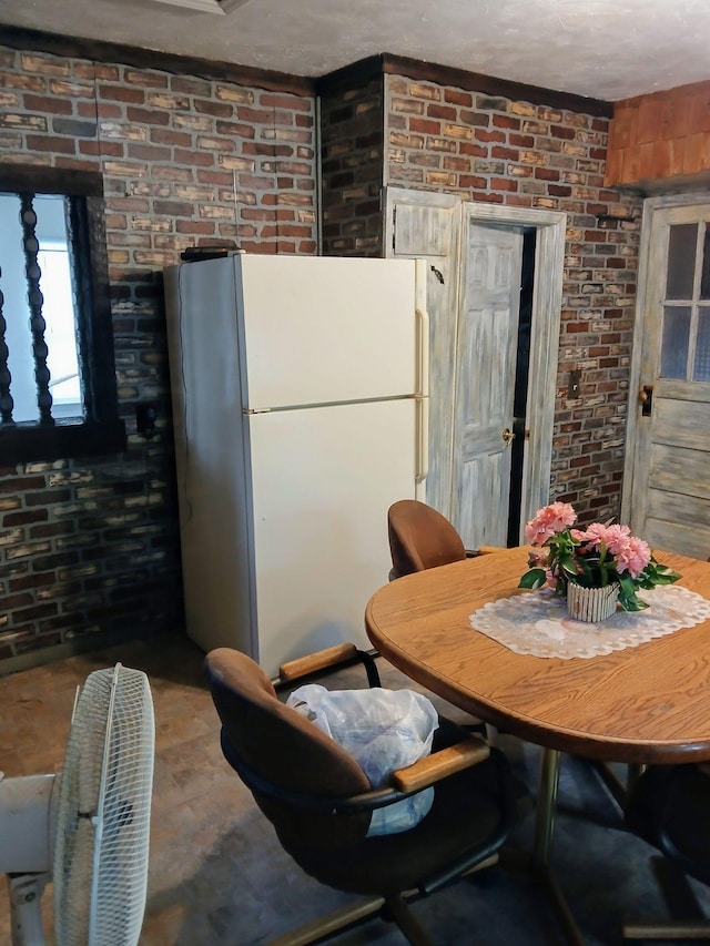 dining space featuring brick wall