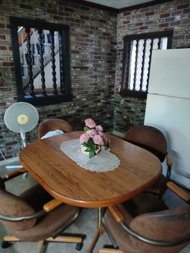 dining space featuring brick wall