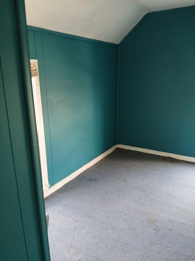 carpeted spare room with lofted ceiling