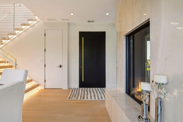 foyer featuring recessed lighting, stairs, wood finished floors, and visible vents