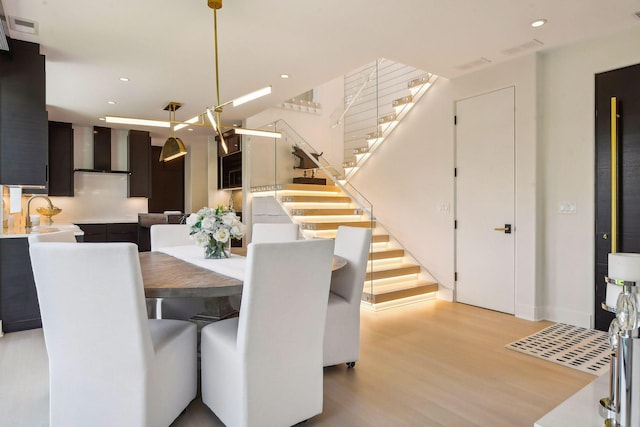 dining room with visible vents, recessed lighting, light wood finished floors, and stairs