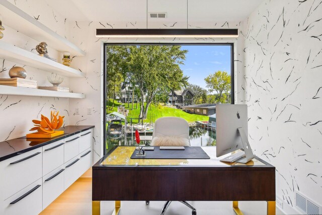 home office with light hardwood / wood-style flooring