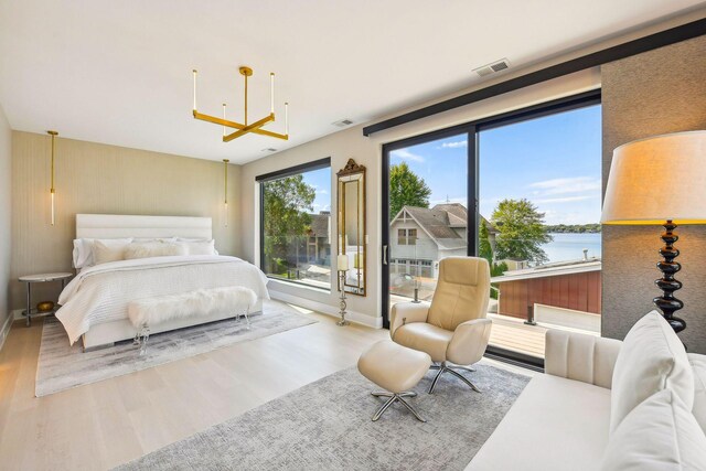 bedroom featuring a water view and hardwood / wood-style flooring