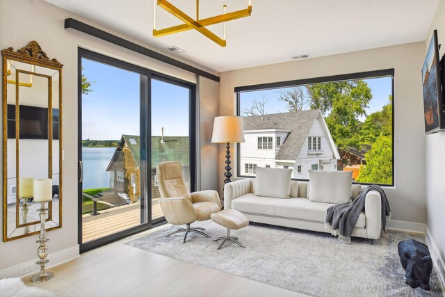 living room with wood-type flooring, plenty of natural light, and a water view