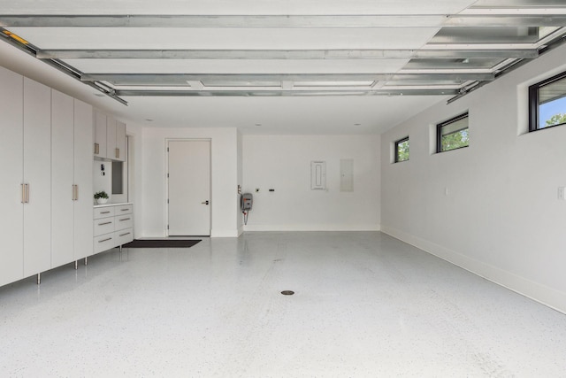 garage with baseboards and electric panel