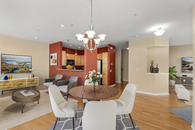 dining room with light wood-style flooring, an inviting chandelier, baseboards, and recessed lighting