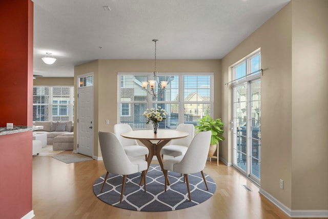 dining room featuring light wood-style flooring, baseboards, and visible vents