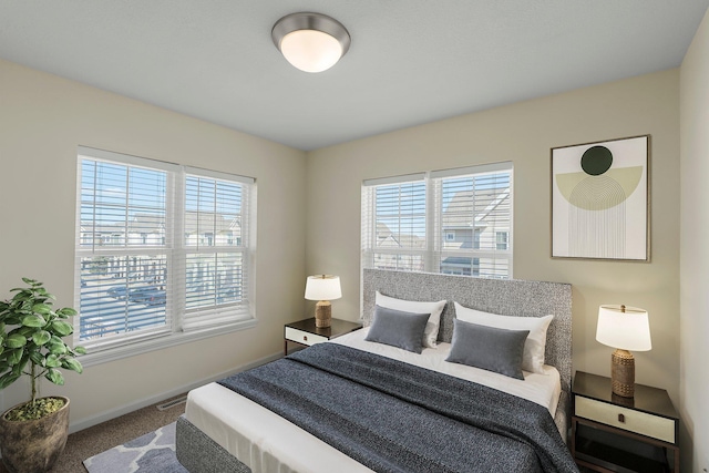 bedroom with baseboards, carpet flooring, and multiple windows