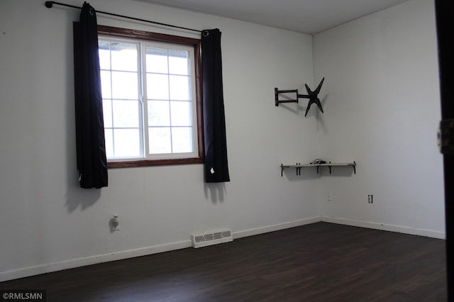 spare room featuring dark hardwood / wood-style flooring