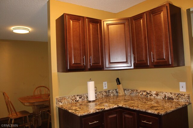 kitchen with light stone countertops and a textured ceiling