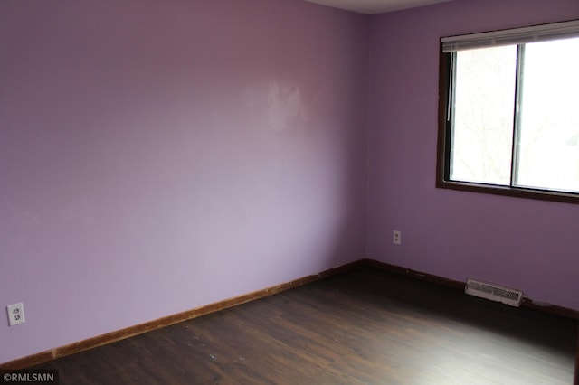 unfurnished room featuring a wealth of natural light and wood-type flooring