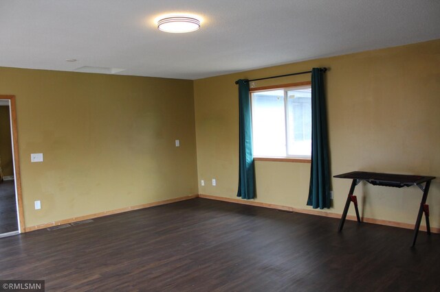 unfurnished room with dark hardwood / wood-style flooring