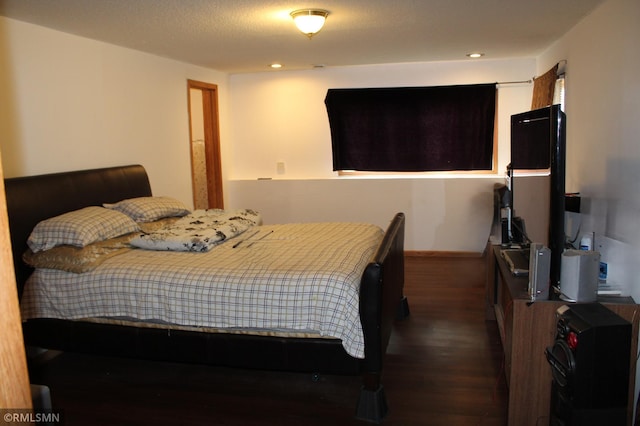 bedroom featuring a textured ceiling and dark wood-type flooring