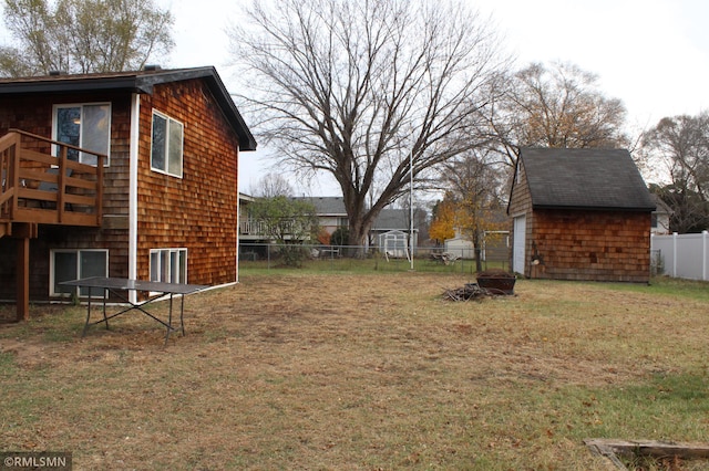 view of yard featuring a storage shed and an outdoor fire pit