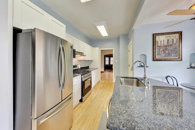 kitchen featuring dark stone counters, sink, white cabinets, appliances with stainless steel finishes, and ceiling fan