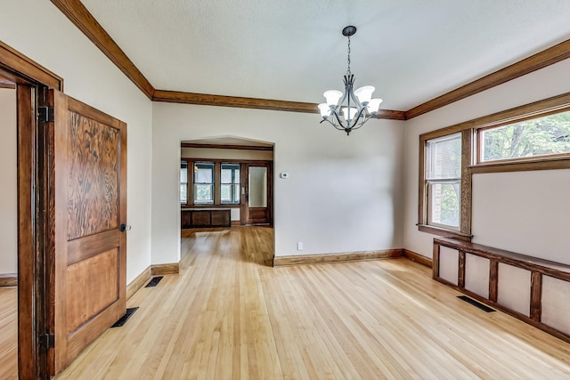 unfurnished room featuring a notable chandelier, crown molding, light hardwood / wood-style floors, and a textured ceiling