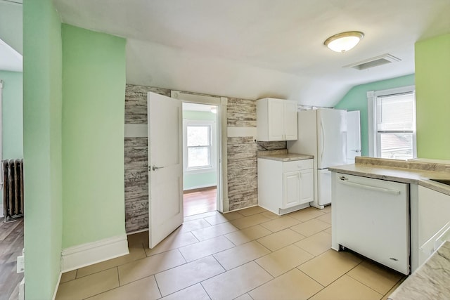 kitchen with white appliances, plenty of natural light, and white cabinets