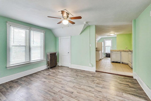 unfurnished living room featuring radiator heating unit, lofted ceiling, light hardwood / wood-style floors, and ceiling fan