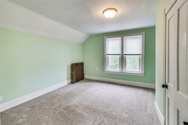 additional living space featuring radiator, vaulted ceiling, and carpet flooring