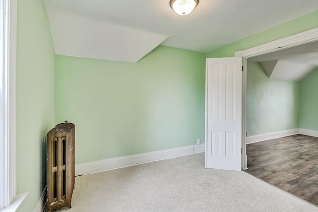 bonus room with light hardwood / wood-style floors and radiator