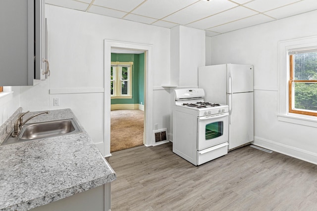 kitchen with light hardwood / wood-style floors, a paneled ceiling, white appliances, and sink