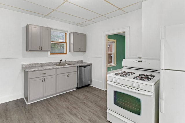 kitchen featuring a drop ceiling, white appliances, dark hardwood / wood-style floors, and sink