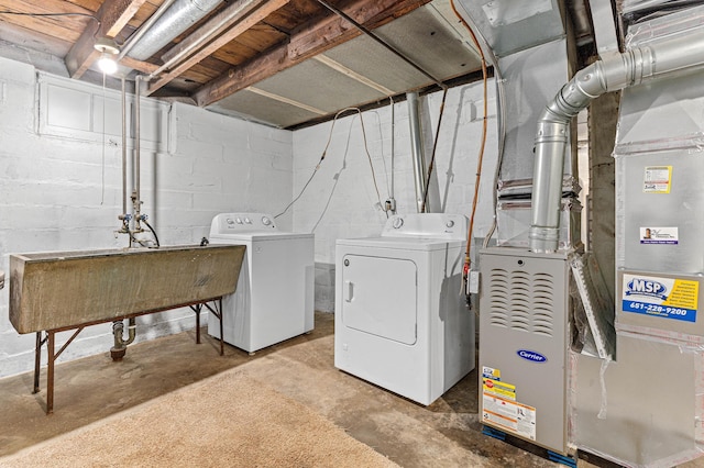 clothes washing area featuring washer and clothes dryer and heating unit