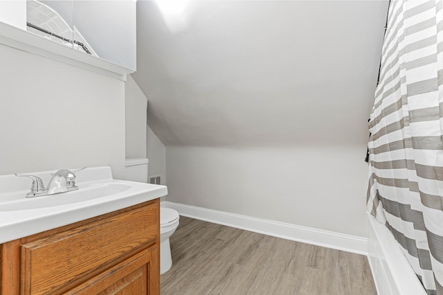 full bathroom with vanity, lofted ceiling, wood-type flooring, toilet, and shower / tub combo with curtain